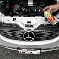 Man applying Fluid Film on Automobile Locks, Hinges, and Tracks