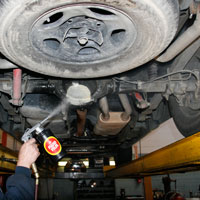 Man applying Fluid Film on Automobile undercoating