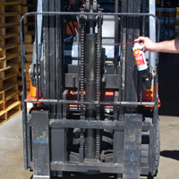 Man applying Fluid Film on Material Handling machine chain