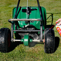 Man applying Fluid Film on Fertilizer spreader