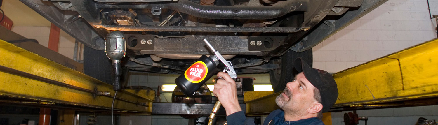 Man applying Fluid Film on automobile undercoating